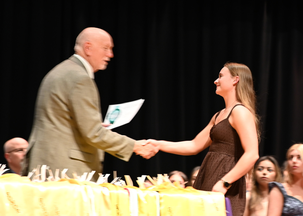Girl shaking hands with man as she is handed a certificate
