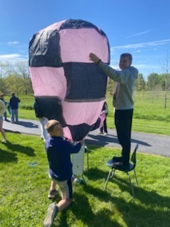 students blowing up an air balloon