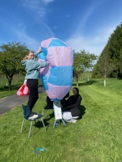 3 Students blowing up an air balloon