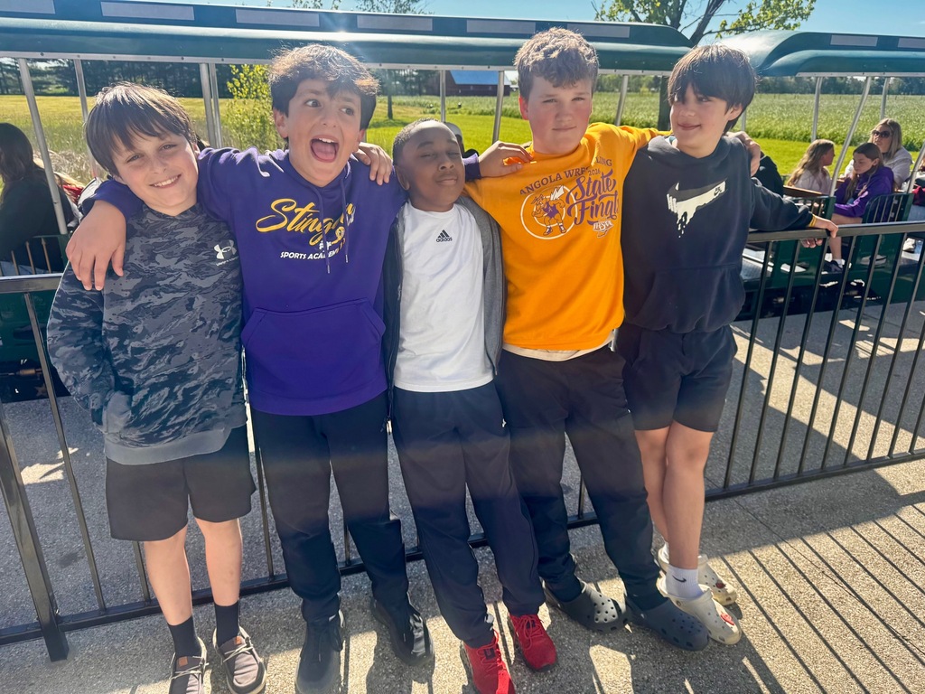 five fith grade boys standin in for making faces in front of a fence