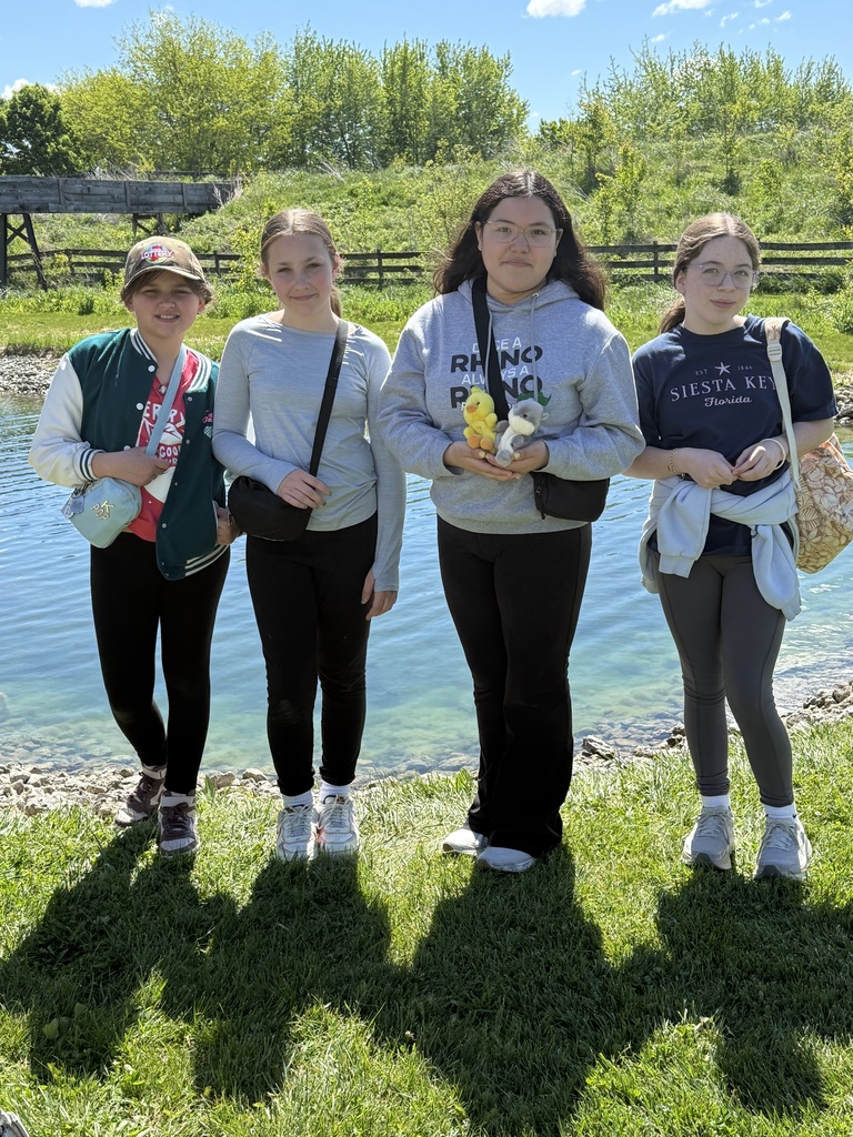 Four 5th grade girls standing in a row smiling at camera