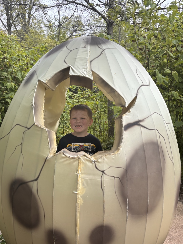 boy looking through a giant  egg sculpture