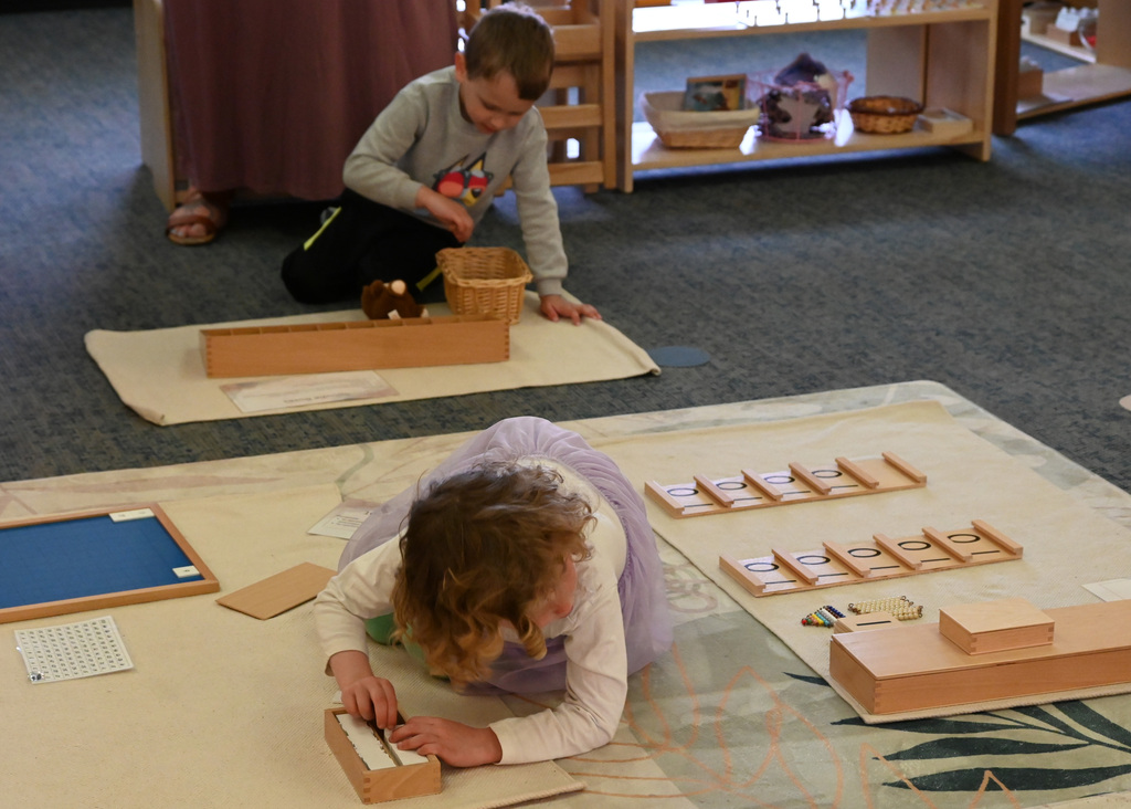 two childern sitting on floor playing word games