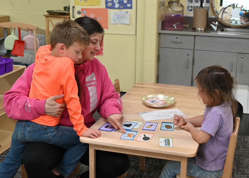 woman and two childeren at table with picture cards