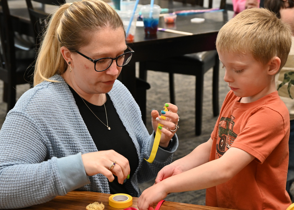 woman and boy using colored tape