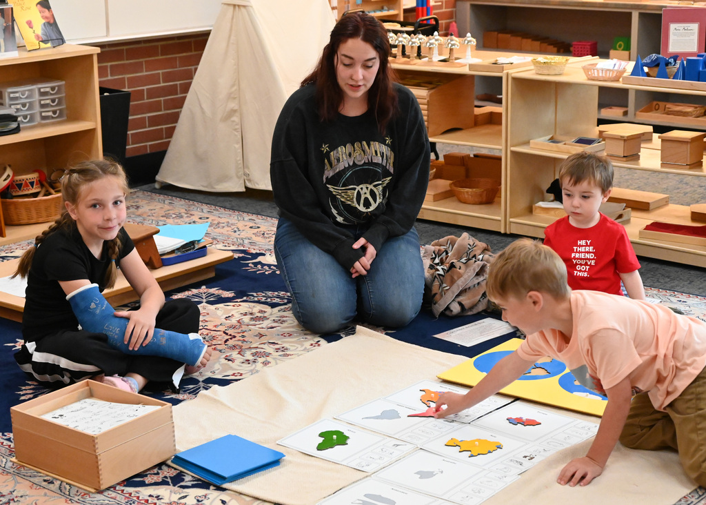 three children stitting on floor playing board game