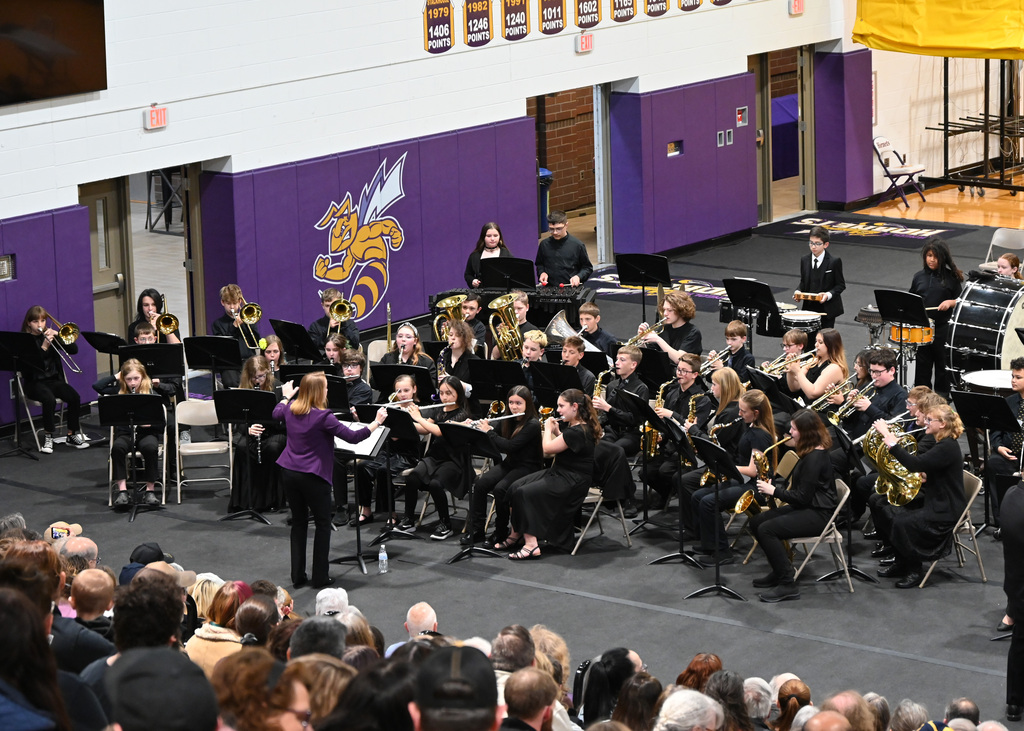 group of 6th grade band students playing in a band being lead by director