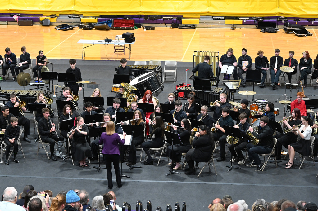 8th grade band students playing being directed by a director