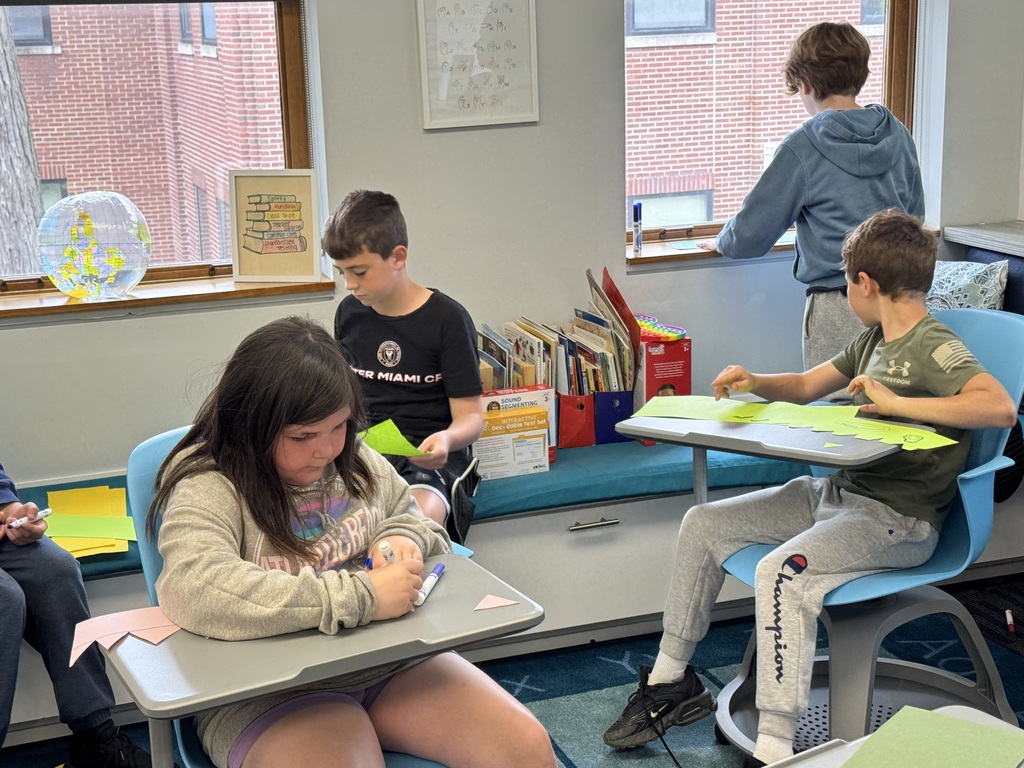 3 students at desks drawing