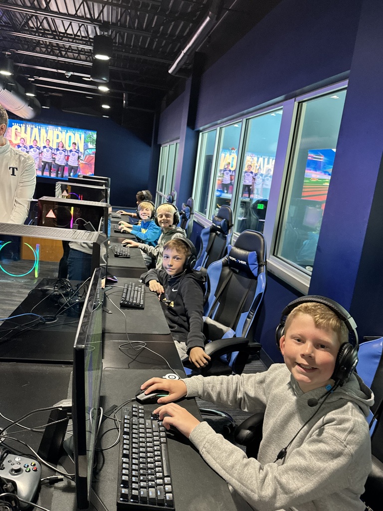 line of kids on computers smilling at camera