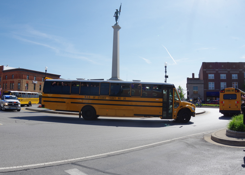 Busses driving a round a pillar monument