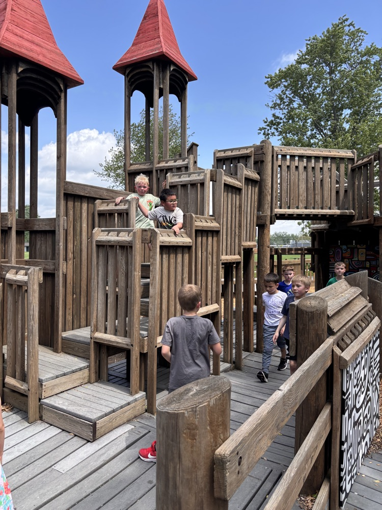 Children playing on a large wooden play area