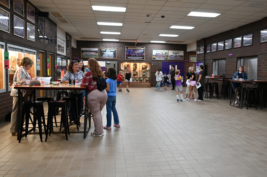 schoentry way of a school with people walking around in it and sitting at tables