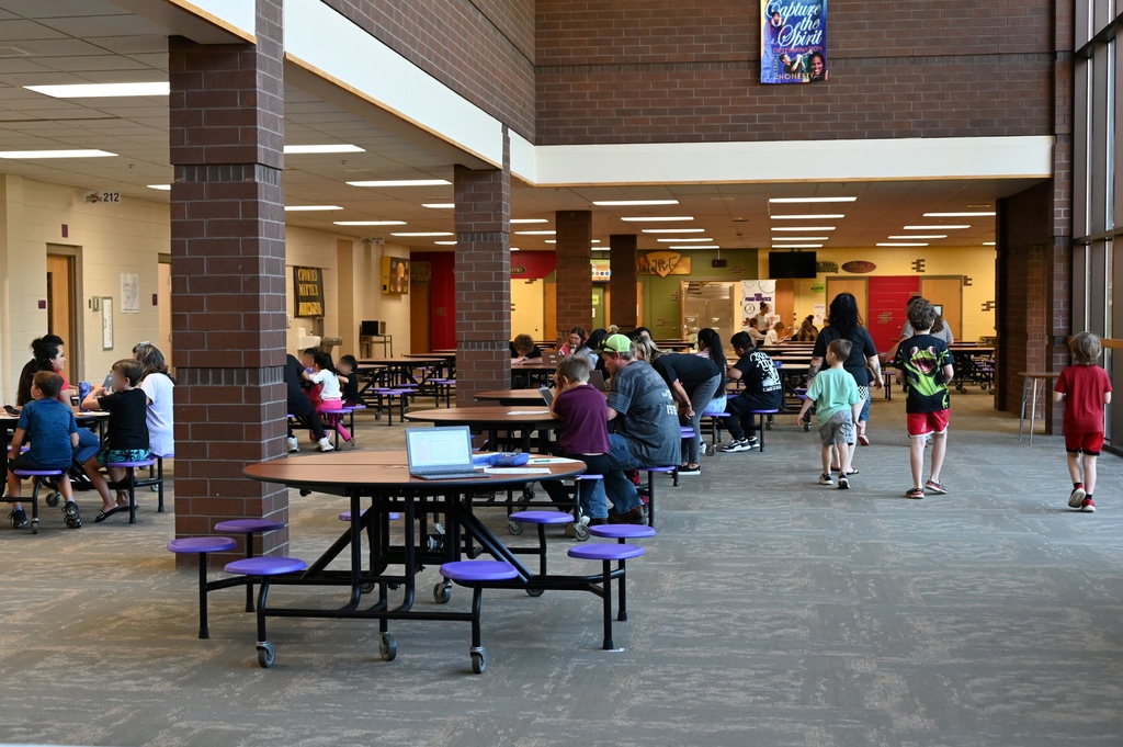 school cafeteria with people walking and at tables
