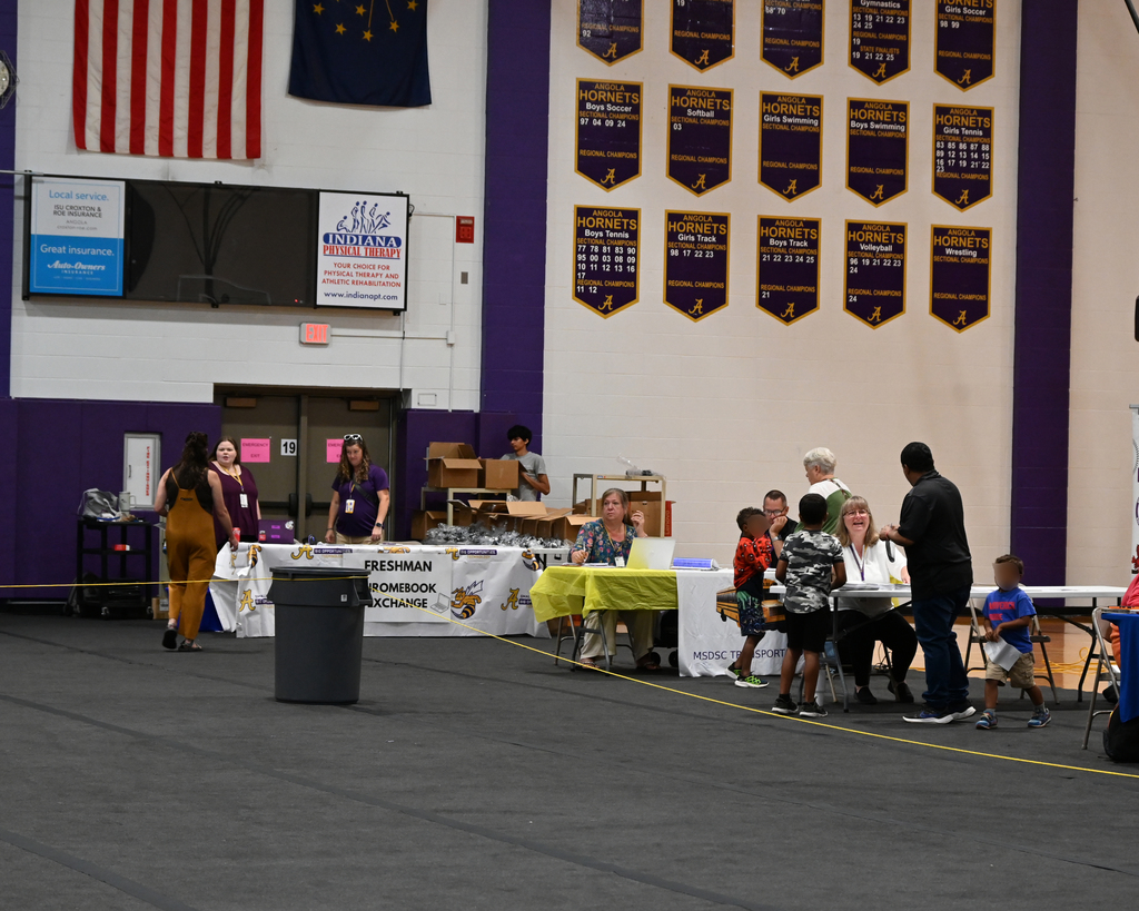 people standing talking around tables in a gyn