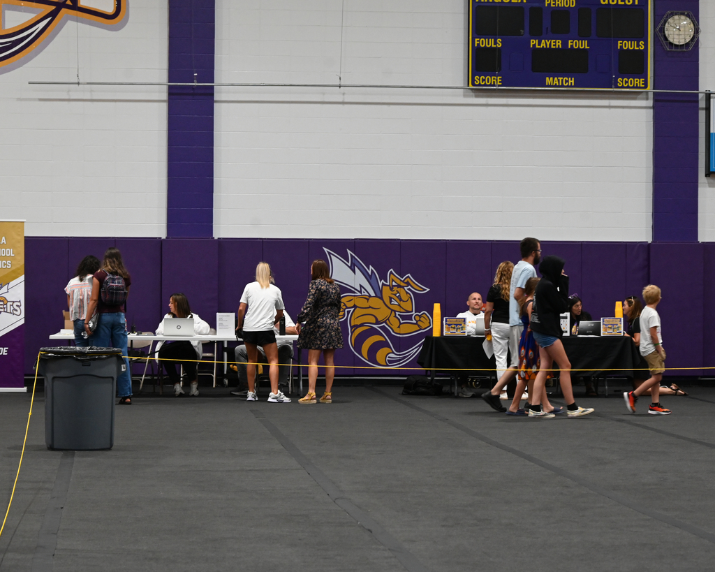 people standing talking around tables in a gyn
