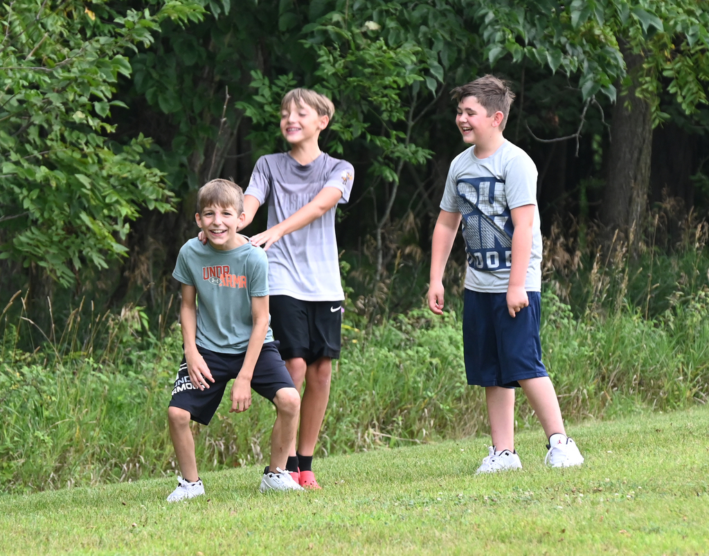 thre boys standing together laughing