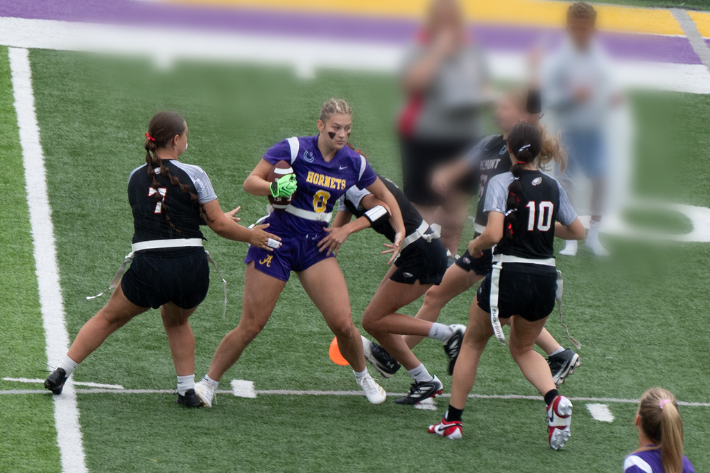Girl with fooball being surronded by other team