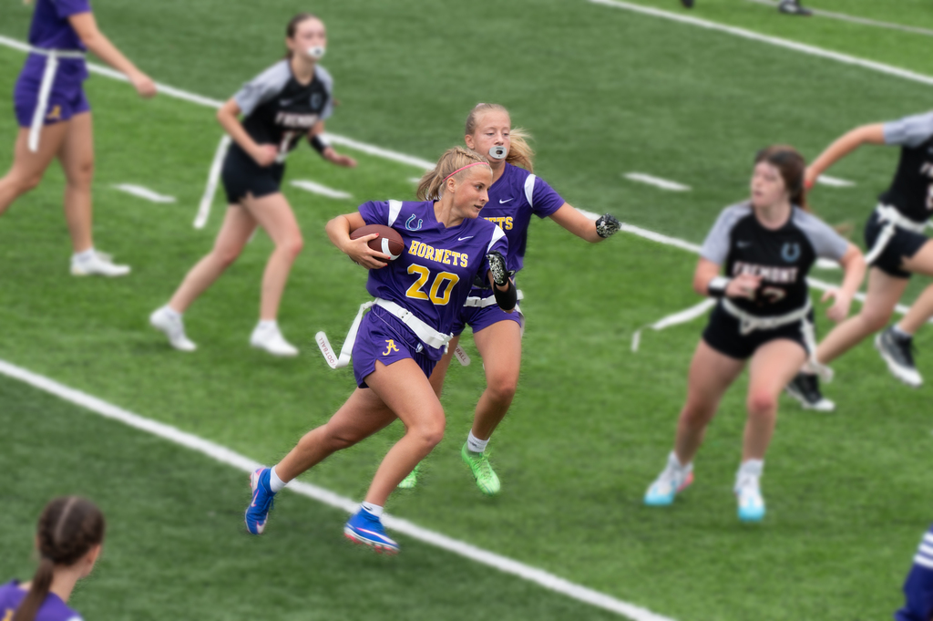 girl in hornets jerasy running wiht a football