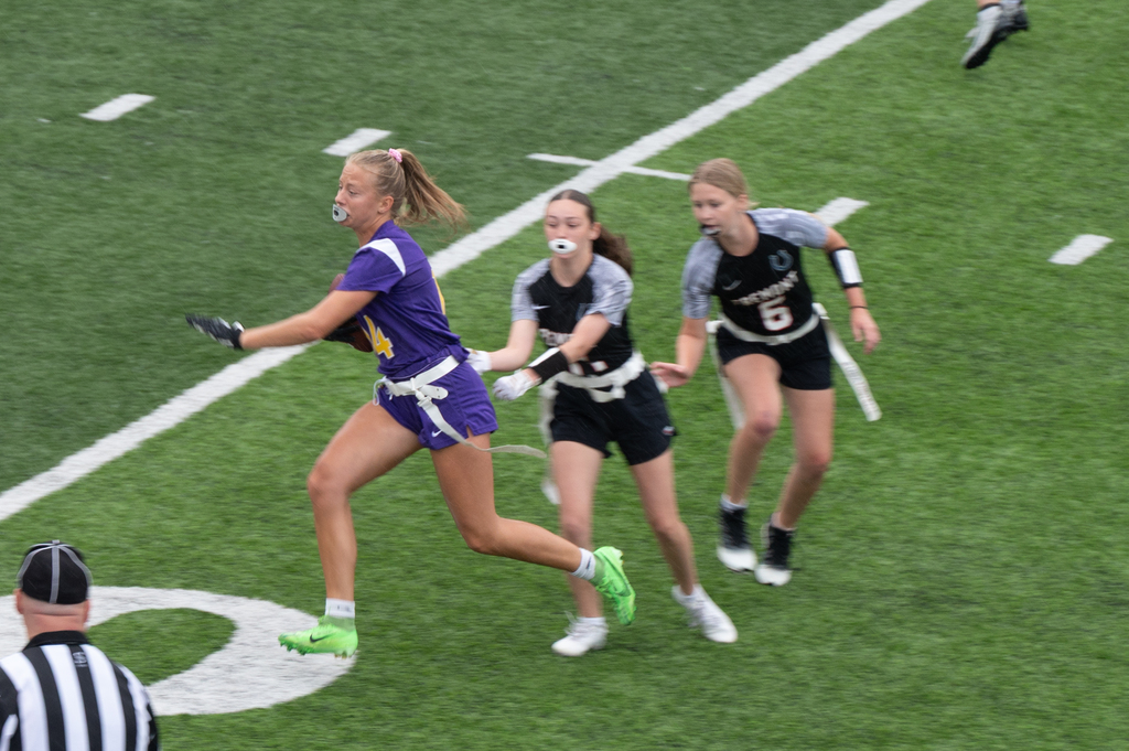 girl in hornets jerasy running wiht a football