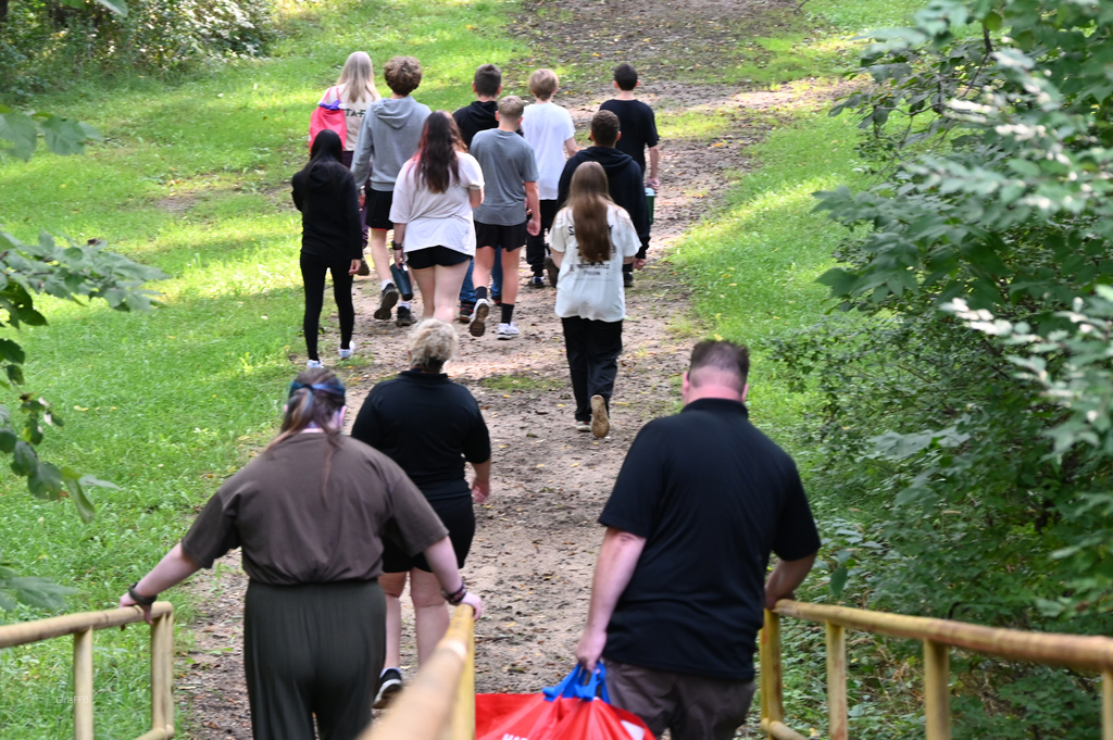 group of people on a trail in the woods