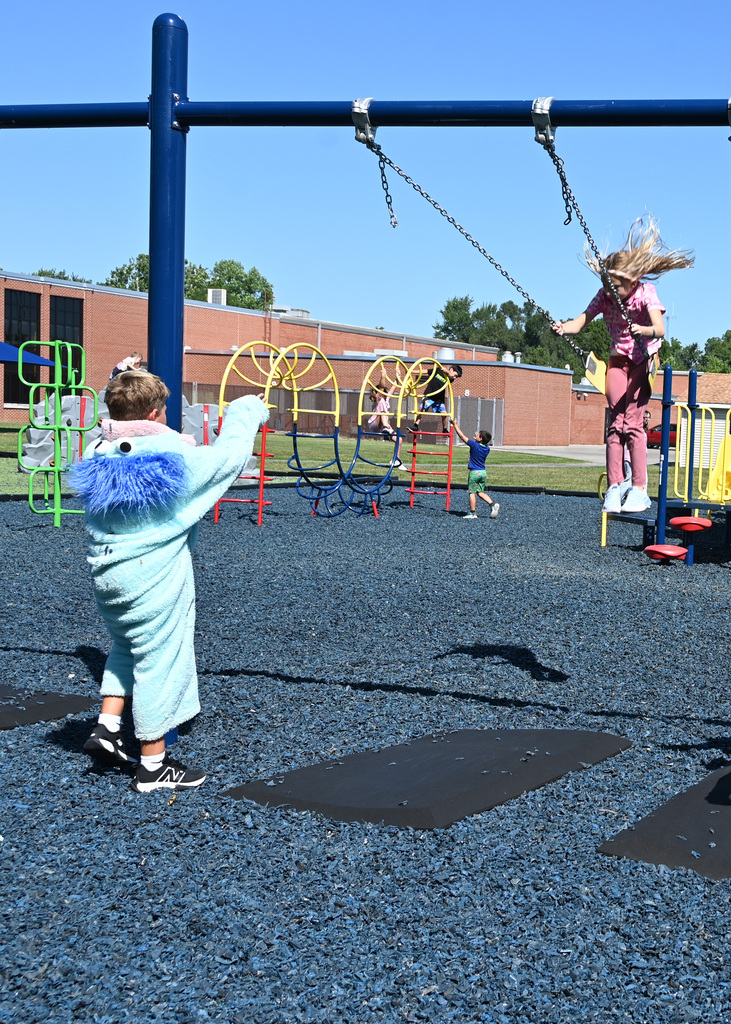 boy pushing girl on swing