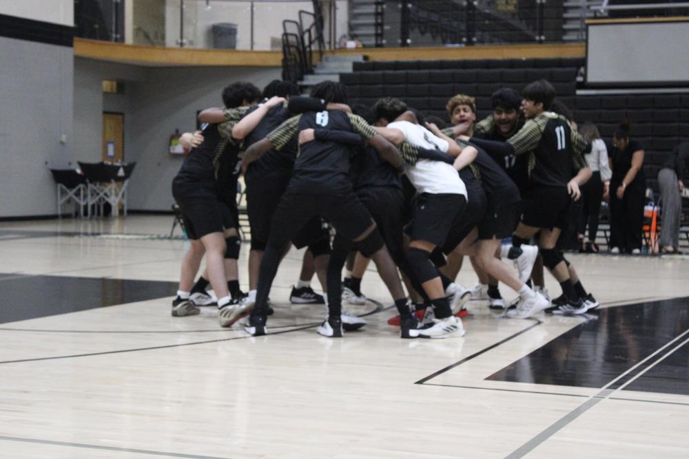 The boys volleyball team huddling during the 2025 season 