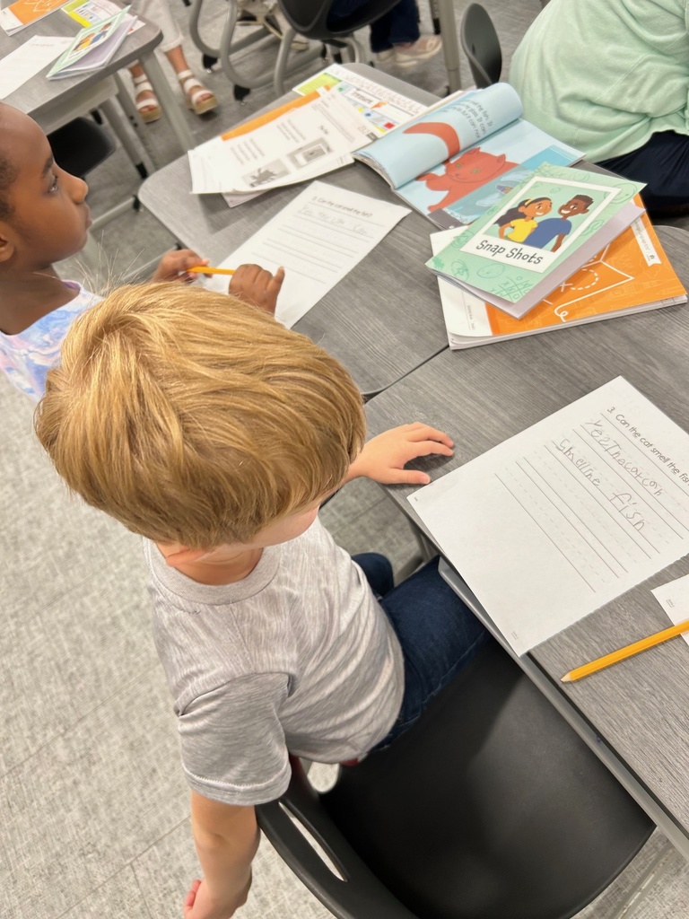 Students answering short answer questions after reading a story together.