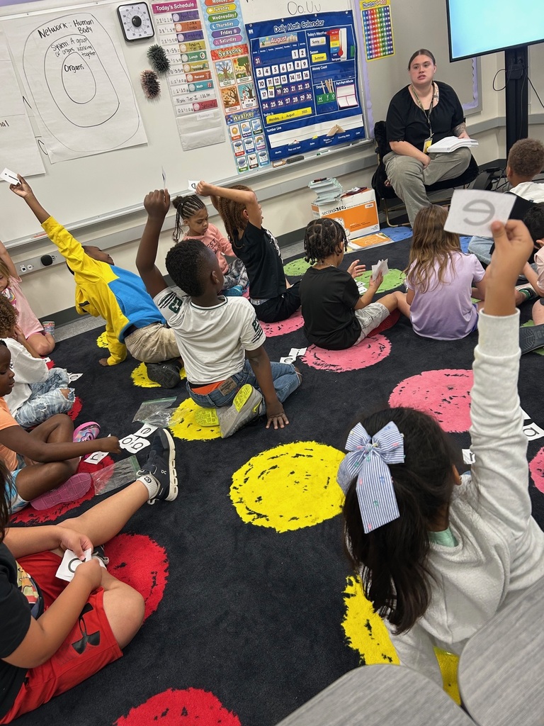 Students engaging in a short vowel isolation activity with CVC words.