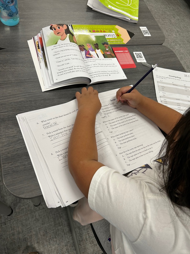 Second grade student using the text to answer comprehension questions.