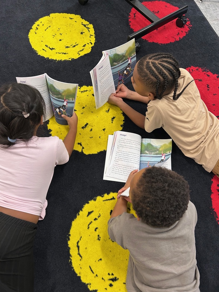 Second grade students reading text in a small group.