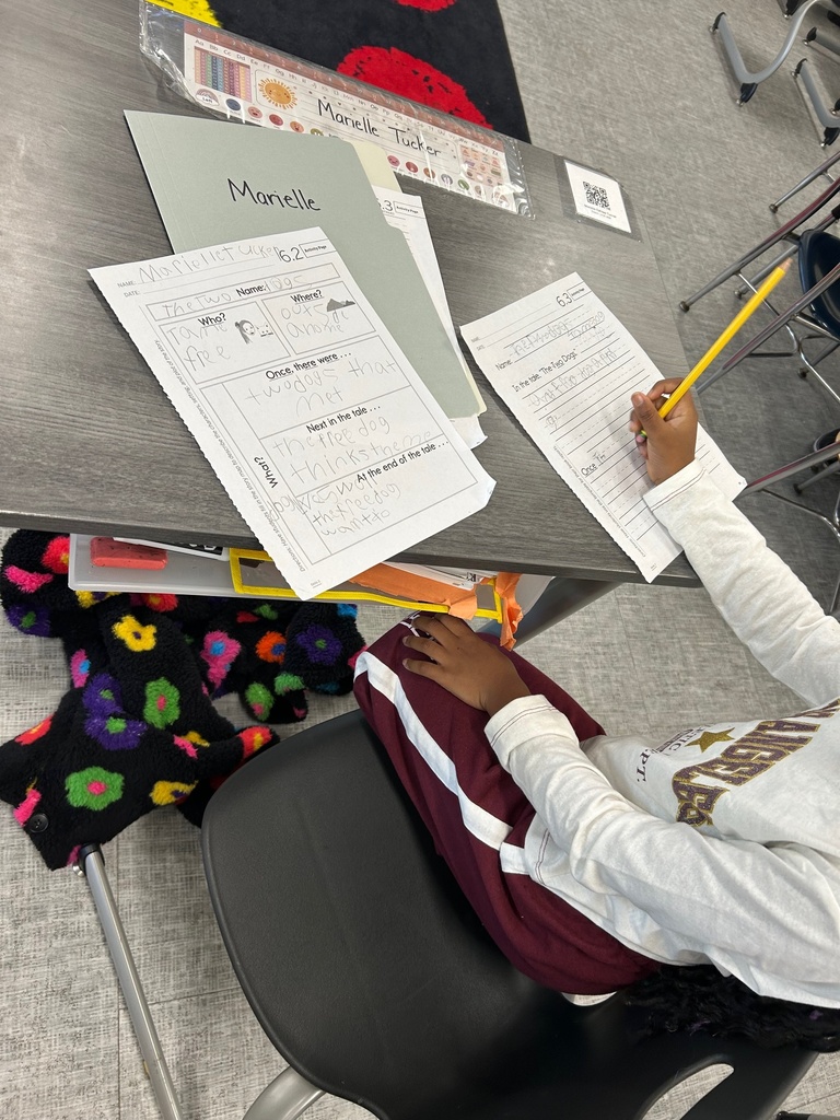 First grade student writing a summary.