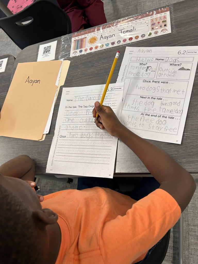 First grade student writing a summary.