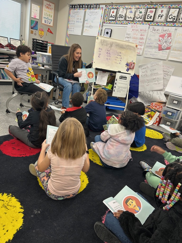 1st grade students reading text in a small group.