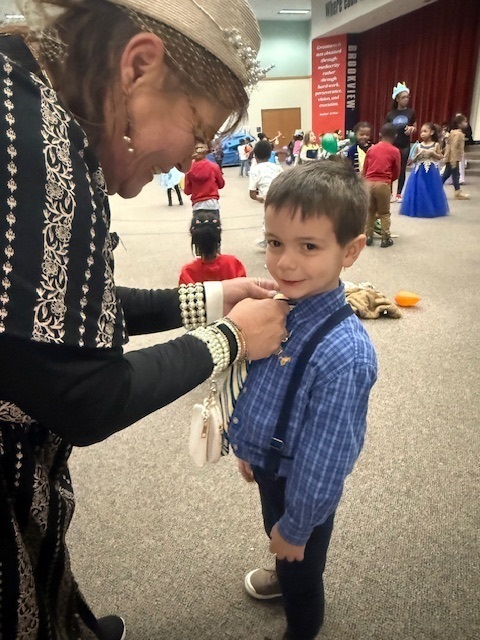 This King is getting his royal outfit straighten by one of our Queens