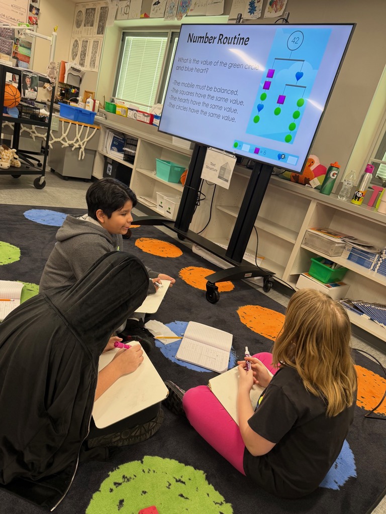 4th grade students working with partners to solve the opening math problem.