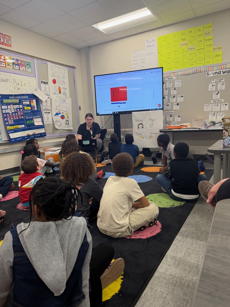 First grade students determining how to measure a book with cubes.