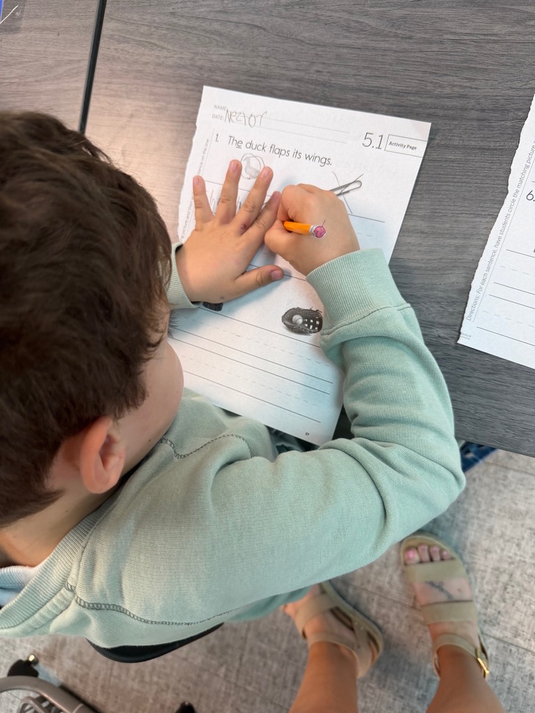 Kindergarten students working on sentence dictation.