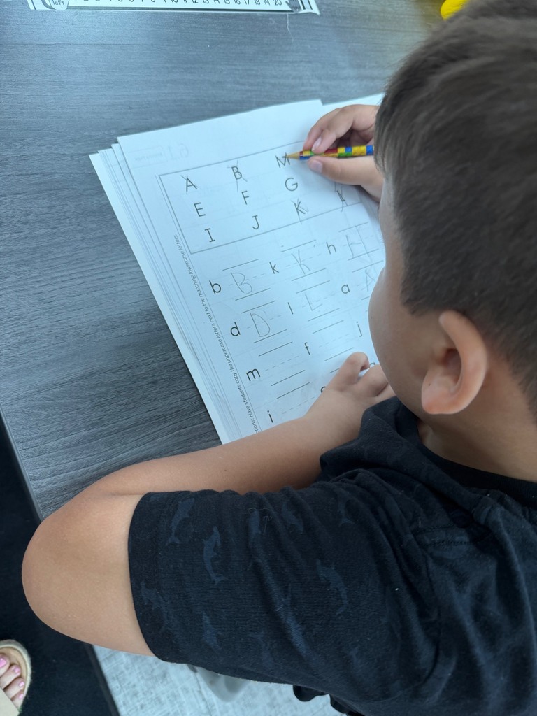 Kindergarten students matching lowercase and uppercase letters.