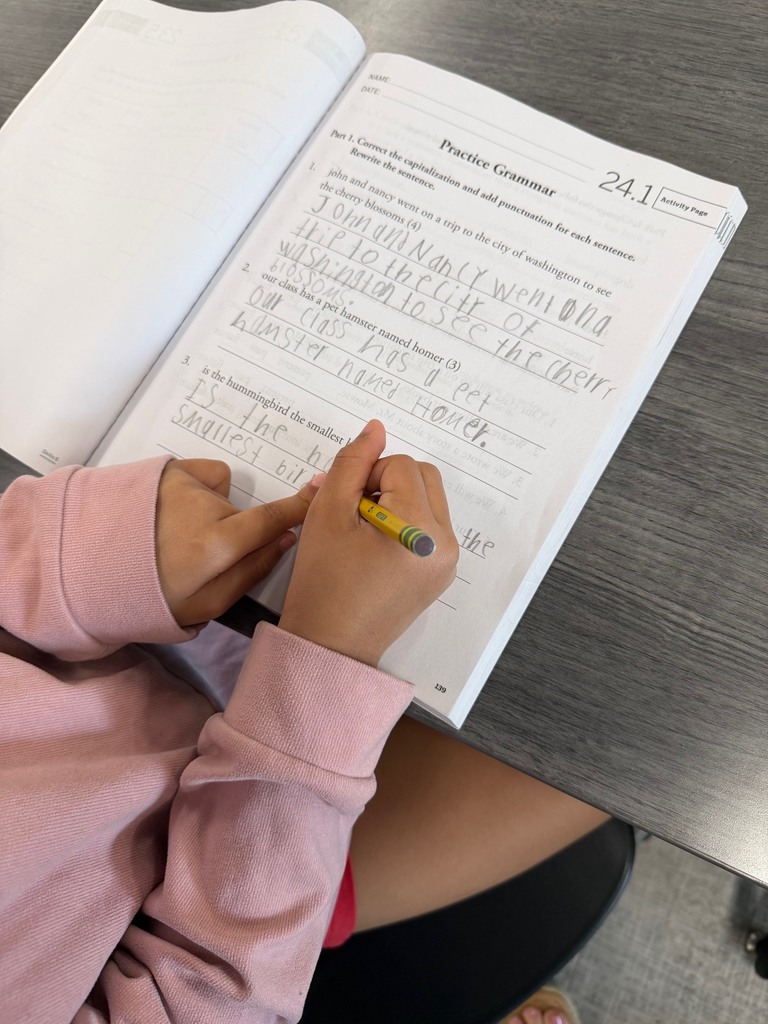 Second grade students correcting sentences with grammar errors.