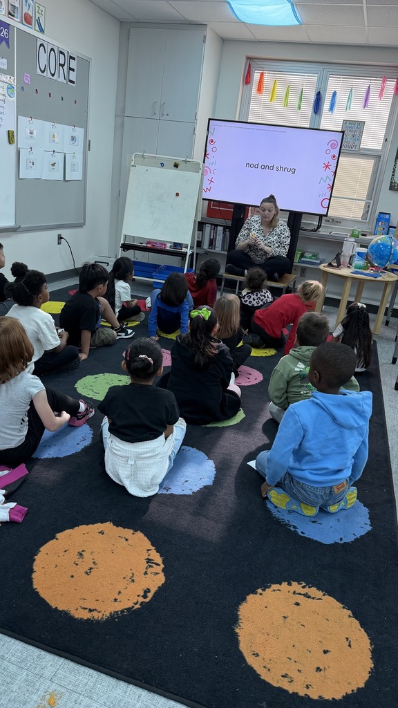 Kindergarten students are enjoying reading the wiggle cards before completing a sentence reading assessment.