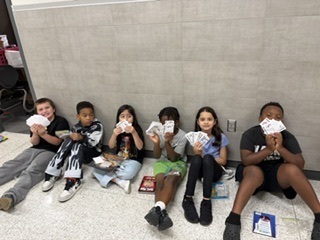 Students showing their CORE cash while waiting to shop in the CORE Store.  