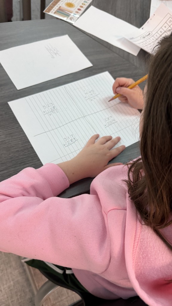 Students practicing multi-digit addition.