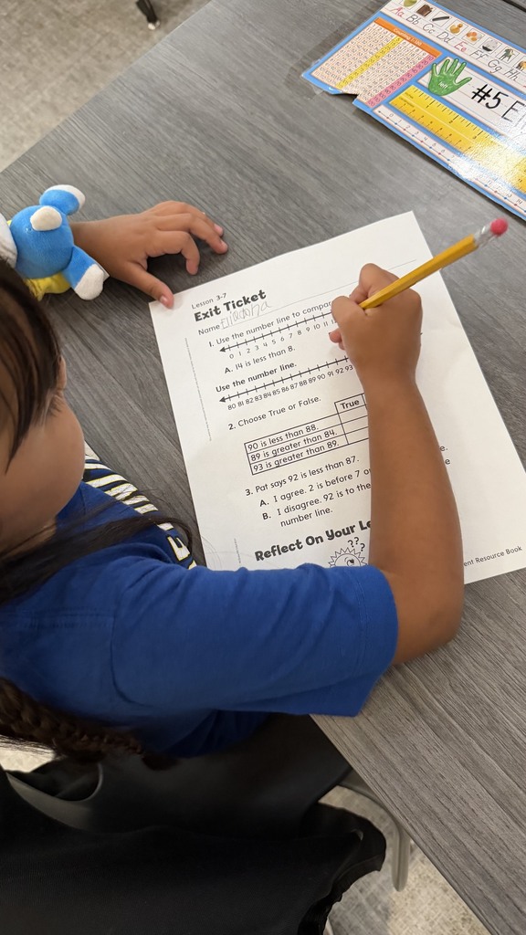 1st grade students working on an exit ticket on comparing numbers.