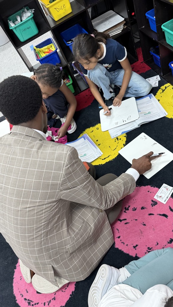 Mr. Butler working with 4th grade students with their math problem.