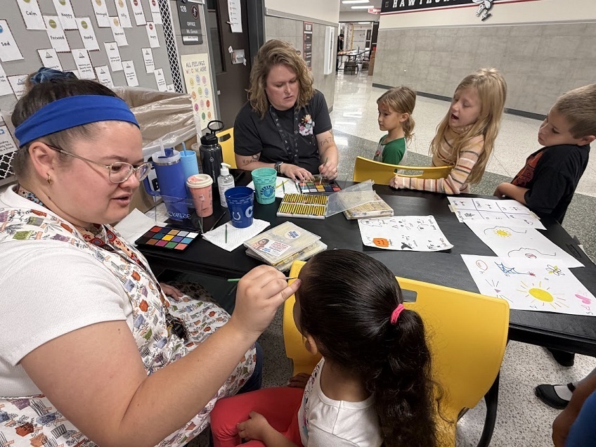 Teacher painting girl's face
