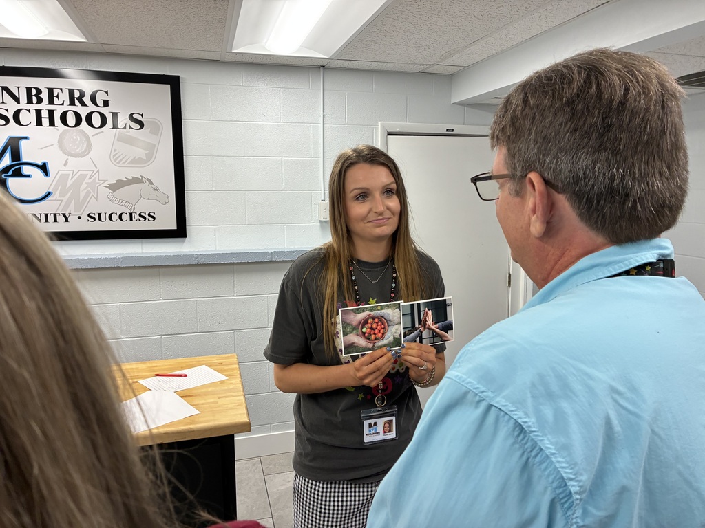 Rachel Baker holding up images reflecting leadership
