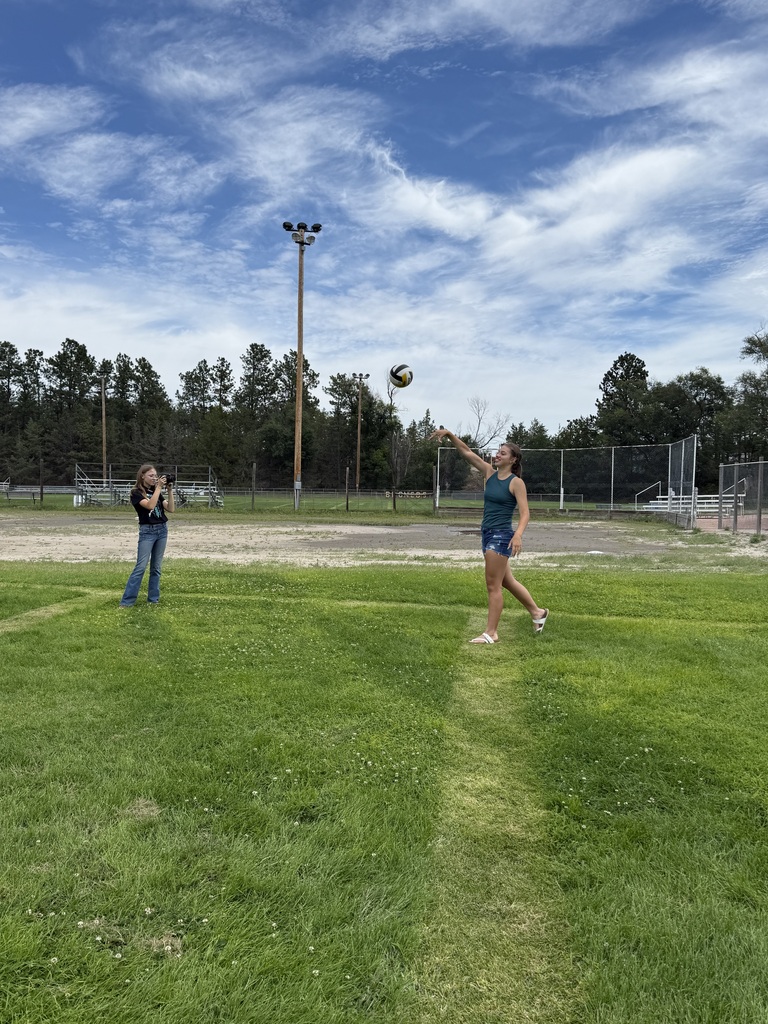 Two students throwing a volleyball