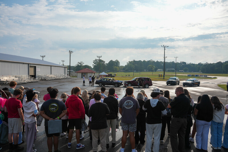 Student groups watch a demonstration of first responders at a car crash