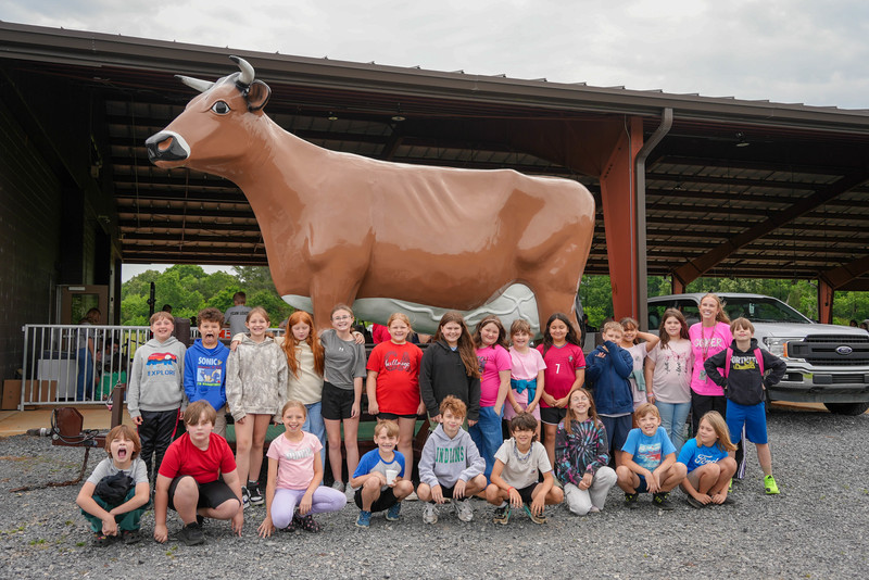 Group poses in front of Mayfield cow